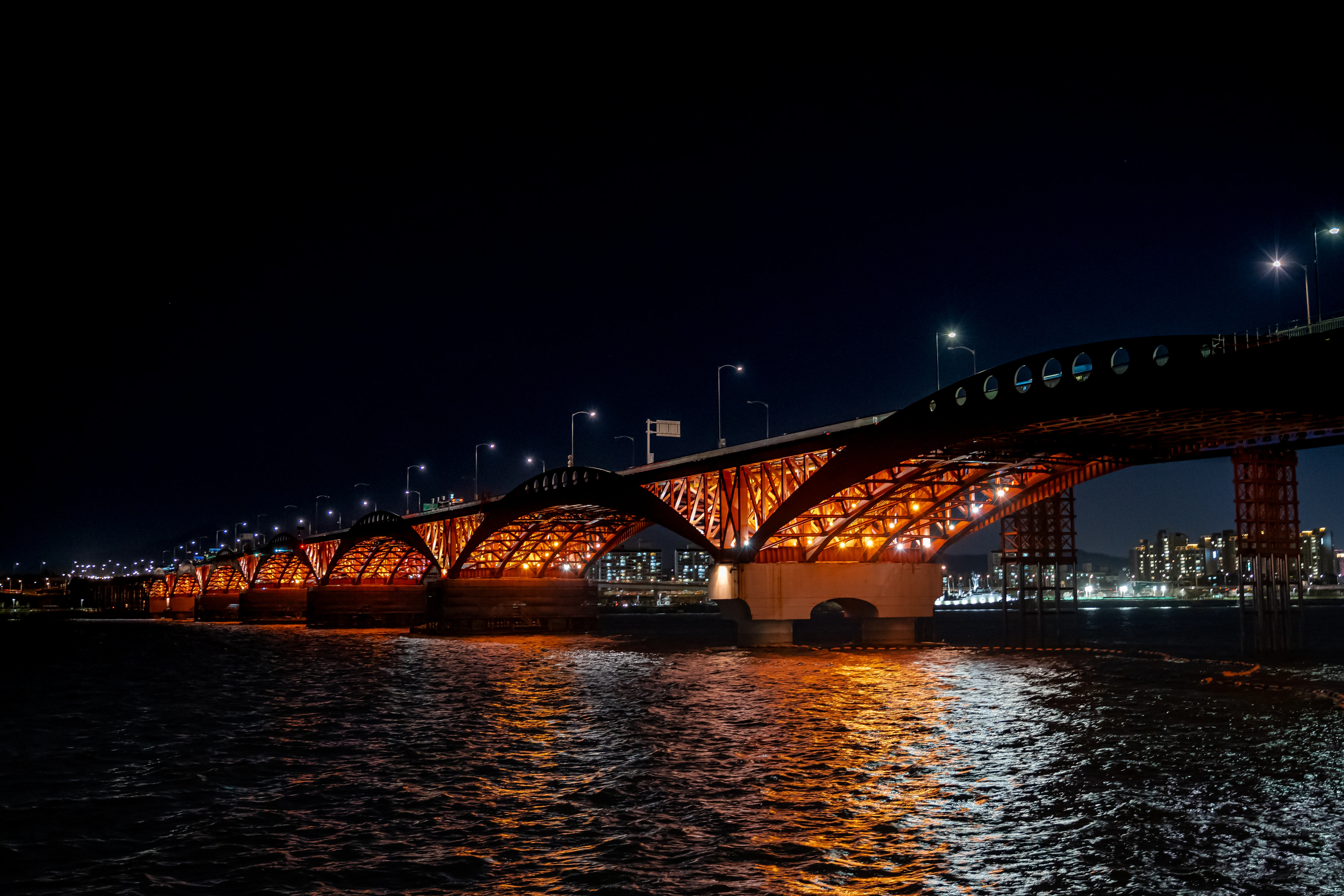 Glowing Night: The Iconic Bridge Illuminated Over Calm Waters